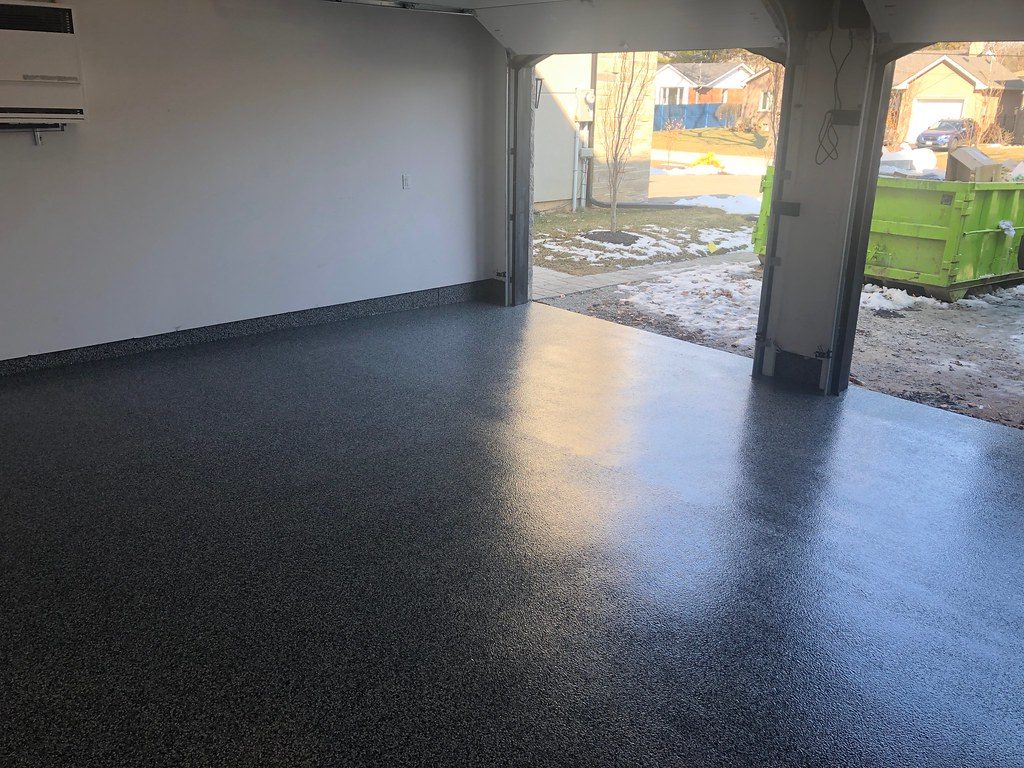 Dark charcoal flake epoxy garage floor looking out to the driveway in Cedar Rapids